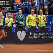 Casey Dellacqua (L) is cheered on by teammates during the second singles rubber of the Netherlands v Australia Fed Cup World Group Play-off tie in 's-Hertogenbosch; Henk Koster