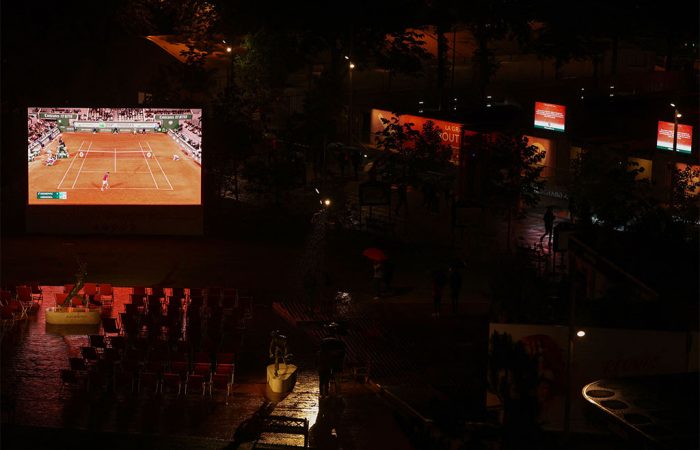 This general view shows a giant screen broadcasting the men's singles match between Japan's Yoshihito Nishioka and Serbia's Novak Djokovic on day two of the Roland-Garros Open tennis tournament in Paris on May 23, 2022. (Photo by Thomas SAMSON / AFP) (Photo by THOMAS SAMSON/AFP via Getty Images)